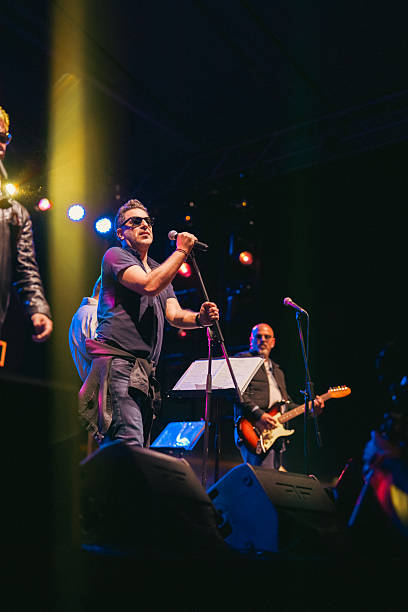 istock Rock Band Vocal Singing Live on Stage with Vibrant Lighting 2227231101