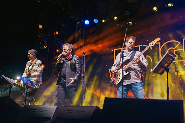 istock Rock Band Performing Live on Stage with Vibrant Lighting 2227231373