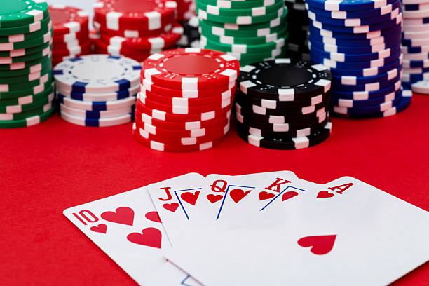istock Gambling chips and royal flush on red background 2227235693