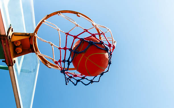 istock Basketball in a net against blue sky 2227235985