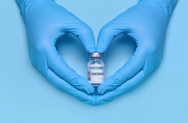 istock Doctor's gloved hands forming a heart shape while holding a Lenacapavir vaccine vial on a blue background, symbolizing HIV prevention, care, innovation in medicine, and copy space for text 2227239880