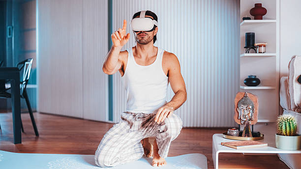 istock Man starts yoga practice with VR headset at home 2227239973