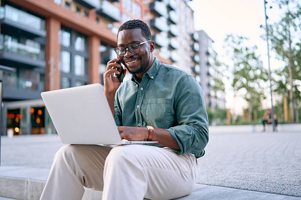 istock Businessman Using Laptop and Phone Outdoors 2227242265