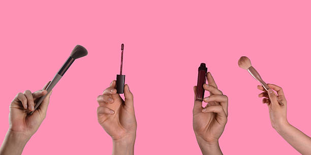 istock Various Makeup Tools and Products in Human Hands on Pink Background 2227243375