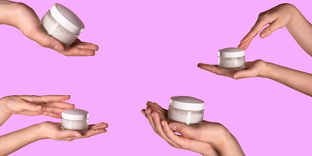 istock Hands Holding Cosmetic Cream Jar on Vibrant Pink Background 2227243642
