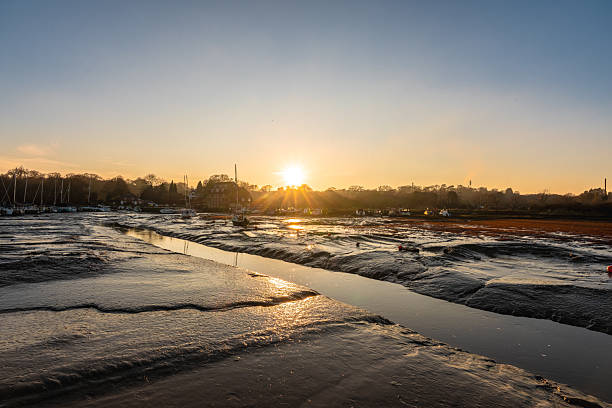 Golden hour illuminating the mudflats and boats at low tide on the river itchen in southampton
