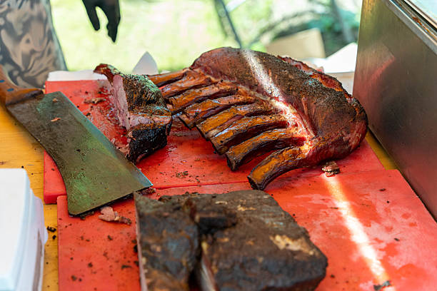 istock Chef cutting smoked ribs and brisket on red cutting board 2227250171