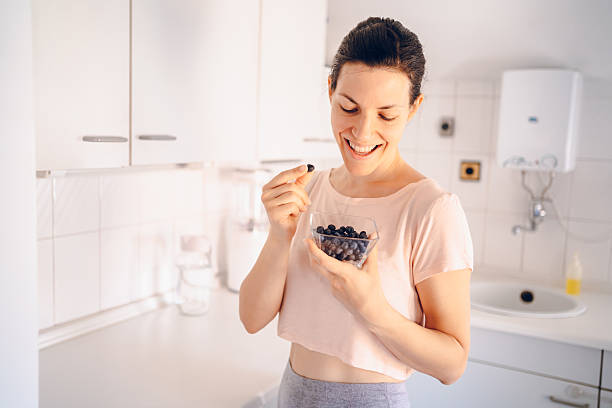 istock Beautiful woman eating blueberries 2227252212