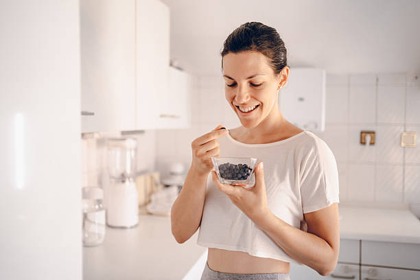 istock Beautiful woman eating blueberries 2227253632