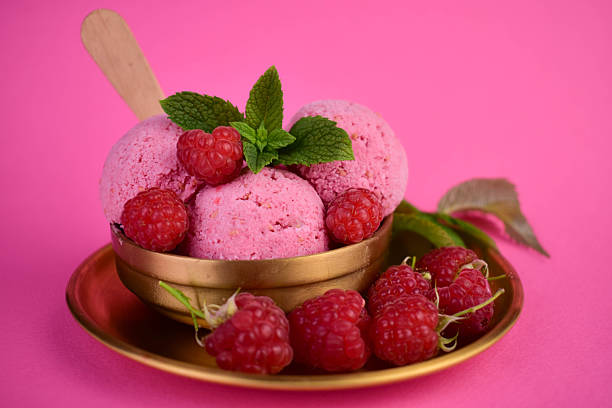 Homemade raspberry ice cream on a bright pink background. Close-up.