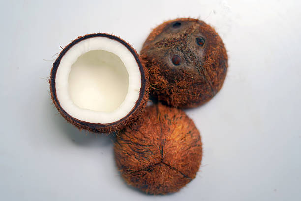 An Afro Caribbean market stall holder shells a coconut to revel its water and flesh