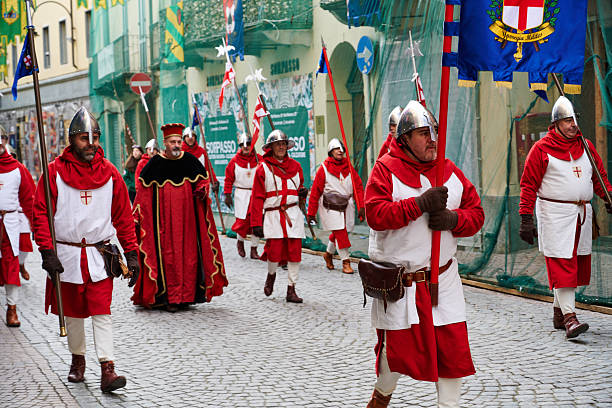 Ivrea, Italy - March 02, 2025: volunteers from local communities taking part to the grand historical parade of Ivrea Carnival featuring participants dressed in medieval costumes. They reenact various scenes from Ivrea's history, paying homage to the town's fight for independence.