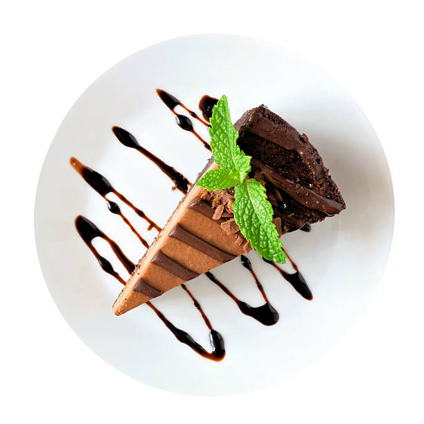 Slice of chocolate cheesecake on plate, above view isolated on a white background