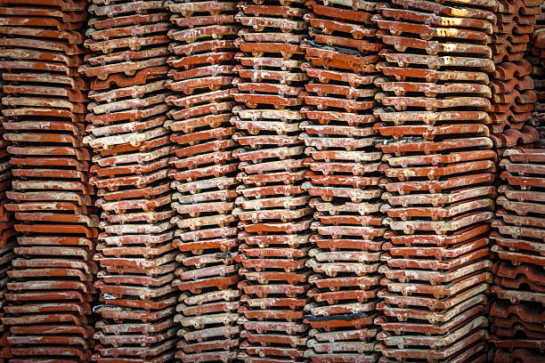 terracotta clay roof tiles stacked high abstract wide background. construction design element with copy space