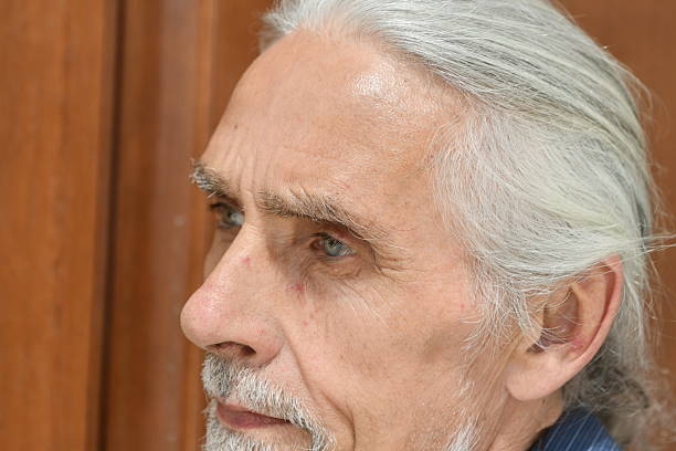 Elderly Man Indicating Numbers with His Fingers