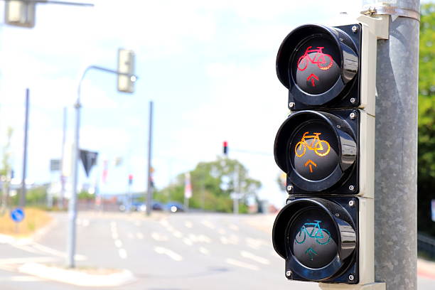Close-up of a pedestrian traffic signal showing the green walking figure, indicating it’s safe to cross. Behind the light, traffic signs warn about parking restrictions and potential towing, highlighting urban road regulations and safety infrastructure.