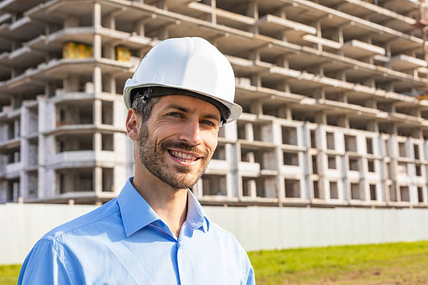 istock Young smiling man architect wearing a helmet looking to the camera in building under construction 2227272807