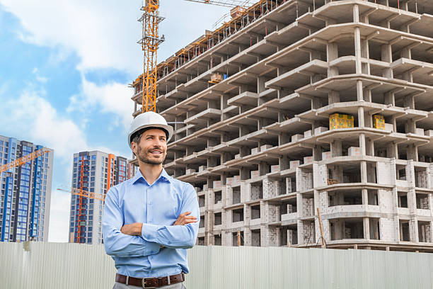 istock Young smiling man architect wearing a helmet looking to the side in building under construction 2227272878