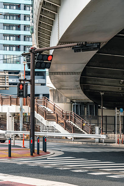 Red traffic light standing under a large elevated highway in tokyo, japan