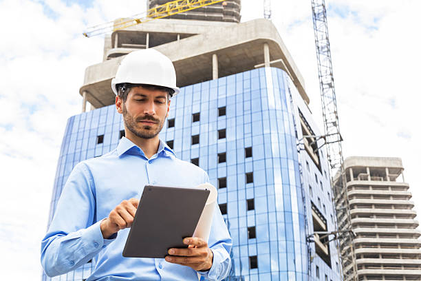 istock Engineer man in helmet use tablet computer for controls construction of skyscrapers, background buildings under construction. 2227272998