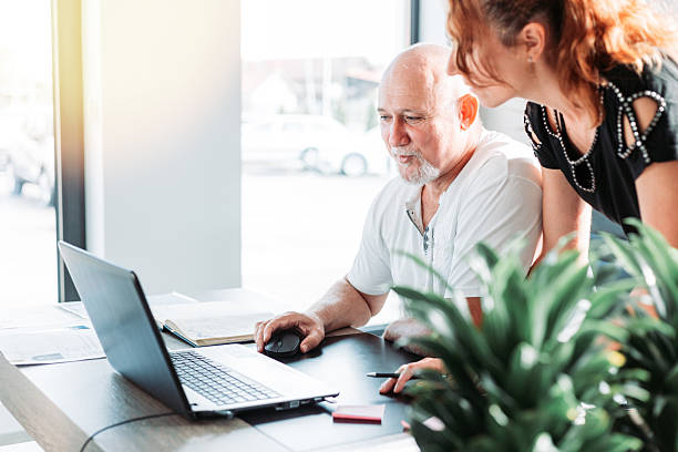 istock Middle aged business man in the office. Assistant standing next to him 2227276514