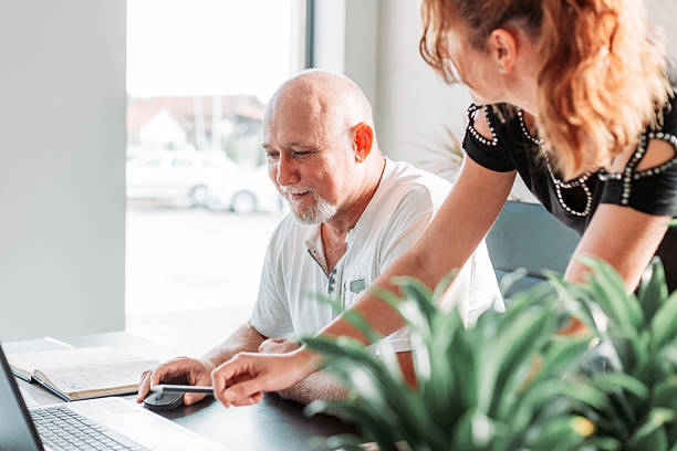 istock Middle aged business man in the office. Assistant standing next to him 2227276516