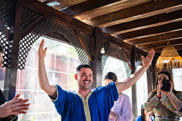 White man celebrating with joyful expression in traditional Arab attire during cultural gathering