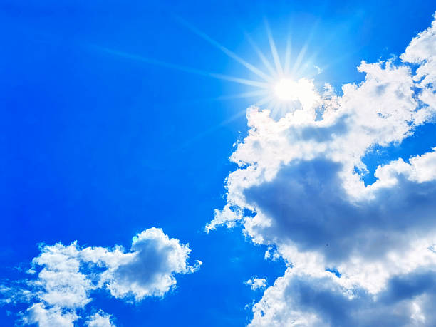 istock Bright sunshine filtering through fluffy clouds in a clear blue sky during midday 2227282120