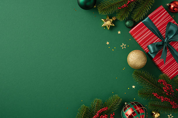 istock Green holiday-themed background featuring a decorative gift box, ornaments, and festive elements symbolizing Christmas celebration 2227284129