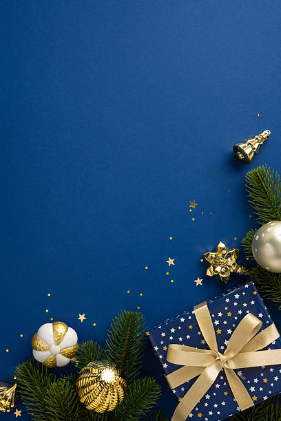 istock Christmas vertical themed arrangement featuring a blue background adorned with golden ornaments and gift boxes. Perfect for holiday celebrations, designs, and festive mood 2227284153