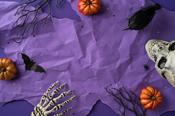 istock A purple paper background featuring Halloween-themed decorations such as pumpkins, a skeleton, a crow, and bats 2227284154