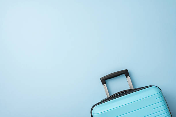 istock A light blue suitcase with a black handle on a pastel blue background evoking travel and holidays 2227284173