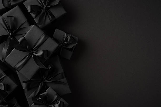 istock Collection of black gift boxes arranged creatively on a dark surface with ribbons. Ideal for themes related to elegant gifting, celebrations, or high-end purposes 2227284212