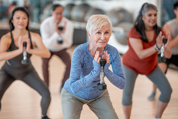 istock Group Fitness Class with Diverse Individuals Engaging in Strength Training 2227288168