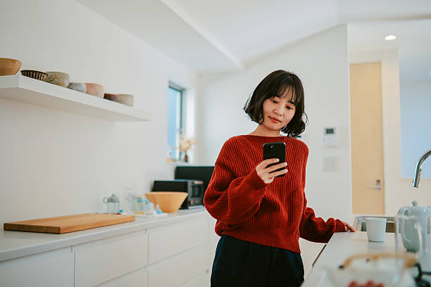 istock Woman reads an article on her smartphone while relaxing at home 2227288434