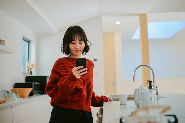 istock Woman reads an article on her smartphone while relaxing at home 2227288499