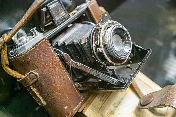 istock Vintage metal camera with corrosion, open front revealing internal mechanisms, dials for focus, aperture, and shutter speed, placed against dark background 2227290118