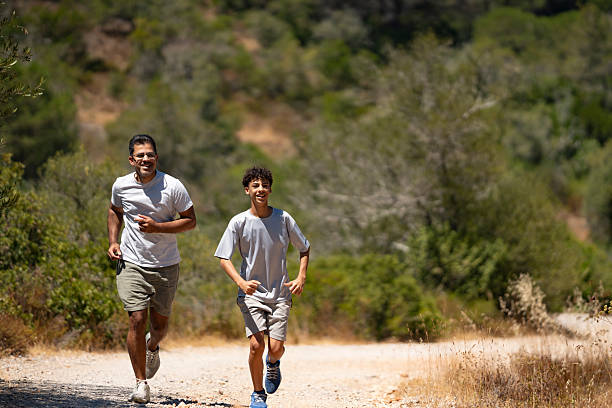 Father and son jogging in nature on a sunny day