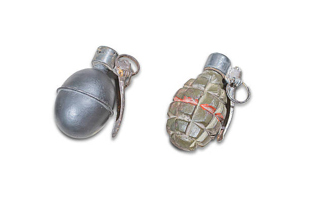istock Two miniature model grenades on a plain background, one silver with a metallic sheen chromesimilar, the other camouflage patterned green, brown, red Both have pull tabs Simple, direct, centere 2227291591