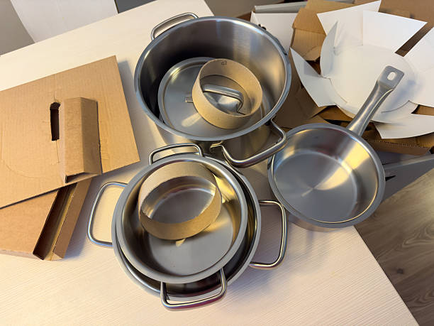 istock New stainless steel cookware set unboxed on kitchen table, cardboard packaging visible, UGC, flatlay 2227292858