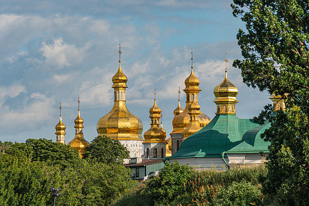 istock Large, grand mosque with multiple domes and minarets Domes adorned with intricate designs, capped in gold White or light-colored stone construction Arched doorways Lush green garden Scattered cl 2227293425