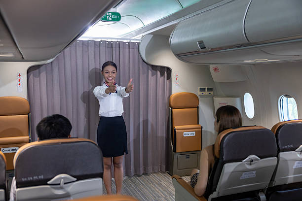 istock African flight attendant is demonstrating safety procedure showing emergency exit before taking off inside airplane for cabin crew and airline business 2227294203