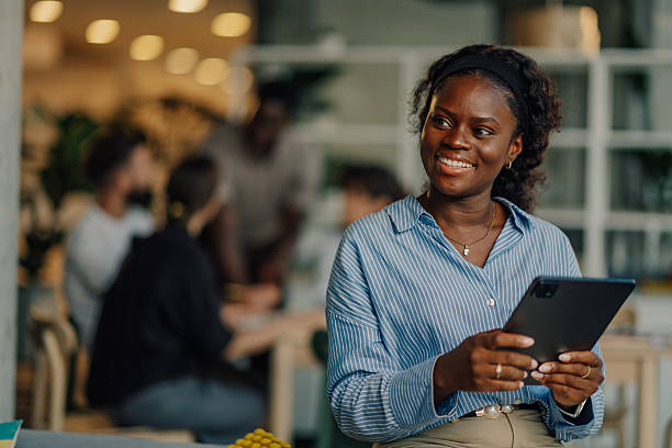 istock Young manager smiling and holding tablet in busy office 2227295515