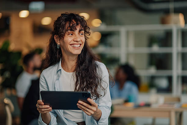 istock Young businesswoman smiling and using digital tablet in modern office 2227295531