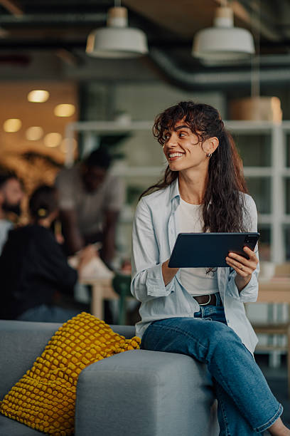 Smiling businesswoman using digital tablet in modern office