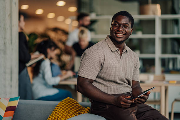 istock Young businessman holding tablet and smiling in modern office 2227295542