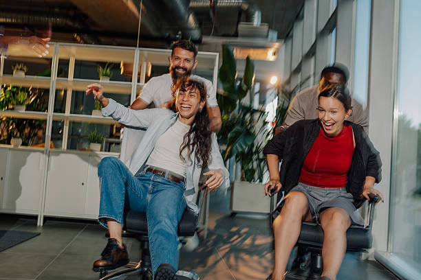 istock Cheerful business colleagues having fun while racing on office chairs 2227295591