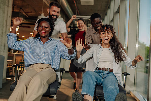 istock Cheerful business team having fun riding office chairs in coworking space 2227295601