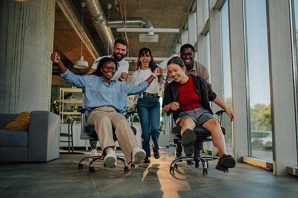 istock Playful business colleagues having fun on office chairs 2227295614