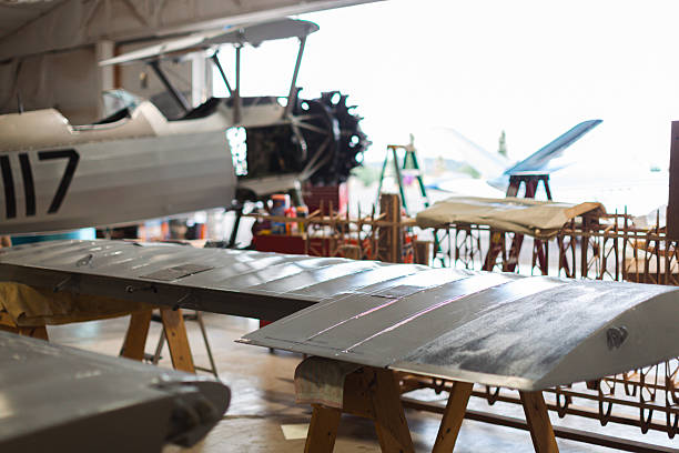 A vintage airplane is being worked on in a hanger for a restoration project. Details of the plane it's self and the project at hand.
